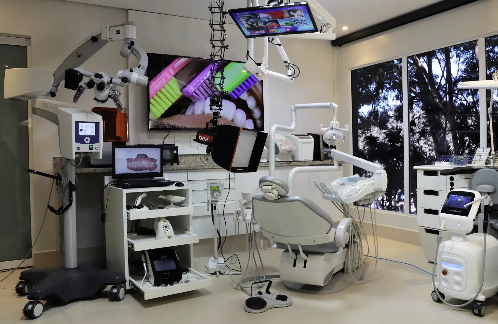 Consultório da Landgraf Odontologia Premier equipado com microscópio odontológico, monitores e equipamentos digitais