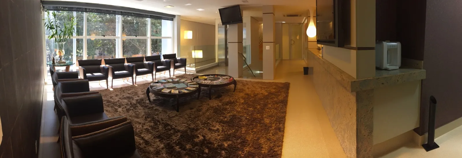 Recepção e sala de espera da Landgraf Odontologia Premier, com luz natural