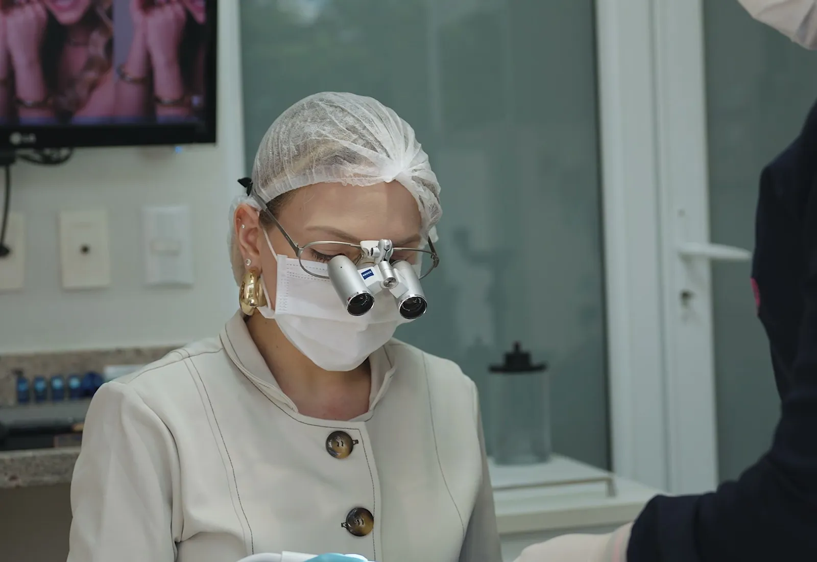 Dentista com lupas de magnificação em atendimento na clínica — tratamento de canal em Palmas/TO